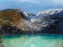Glaciar colgante sobre su laguna de agua turquesa, con bosque de lengas en otoño