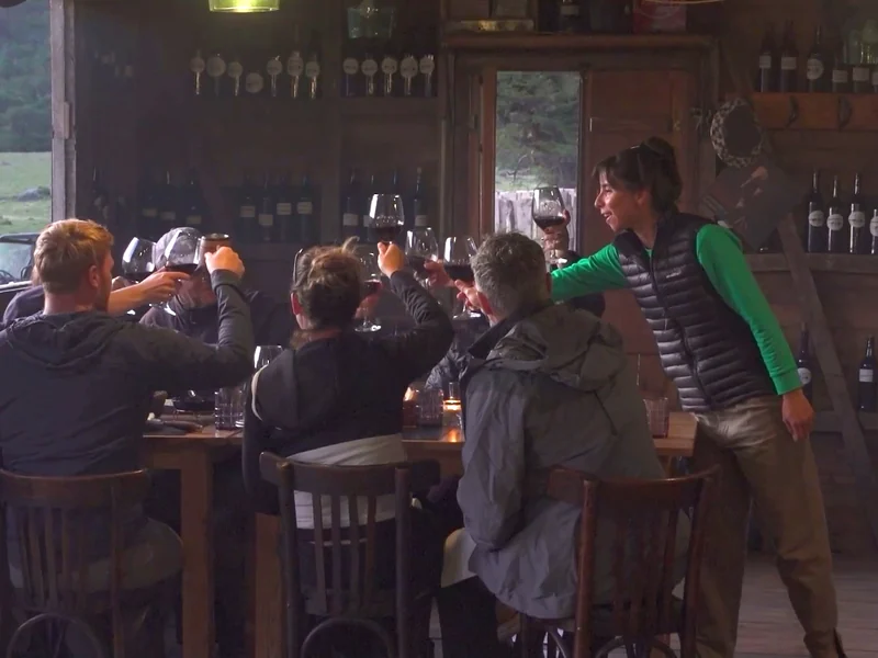 Grupo brindando con vino tinto en la mesa de El Establo, Estancia Bonanza