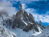 El Cerro Torre nevado entre nubes sobre el glaciar, en el sector de Laguna Torre